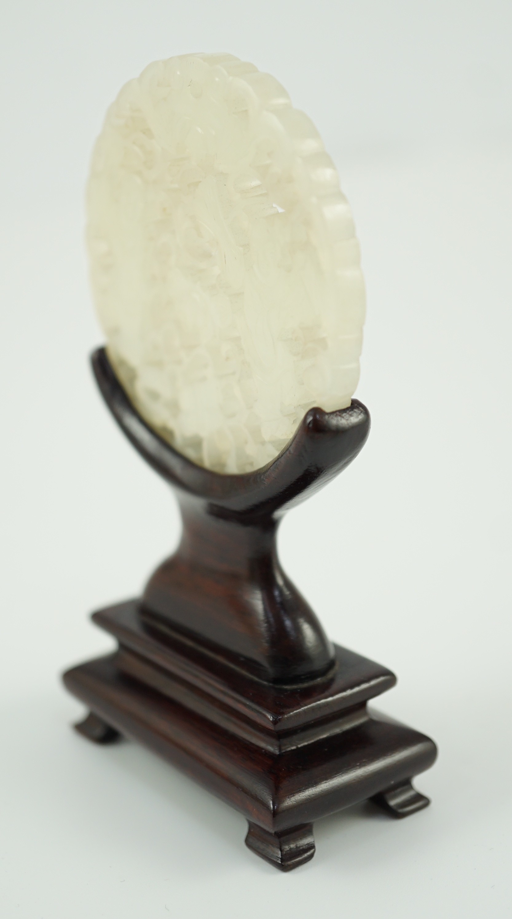 A Chinese white jade ‘Hehe Erxian’ disc, 19th/20th century, 5.6cm diameter, wood stand